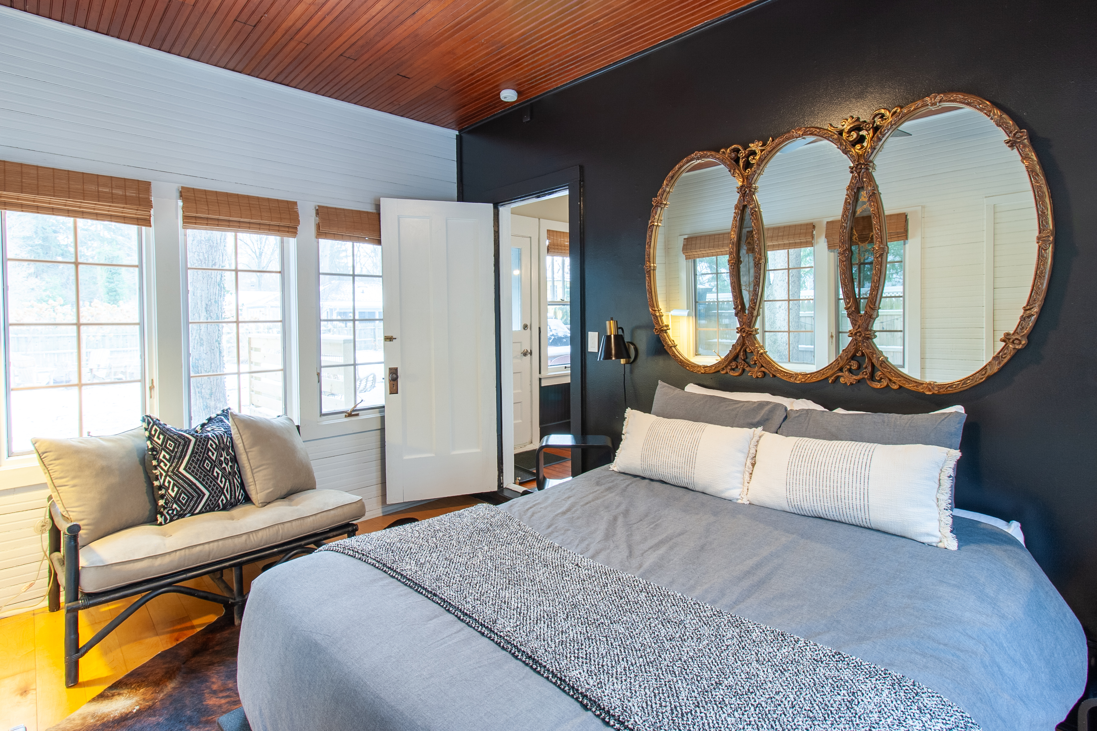 Bedroom with dark walls and round mirrors